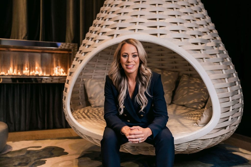 Professional woman sitting in a modern outdoor lounge pod for coaching sessions - Full Pocket Coaching.