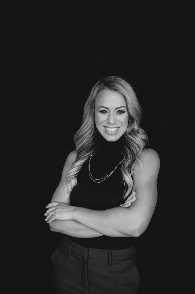 Empowering coaching professional woman smiling confidently in black and white image.